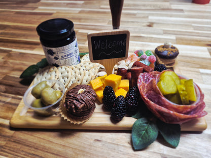 Wooden board with assorted meats, cheeses, and fruits on a wooden surface